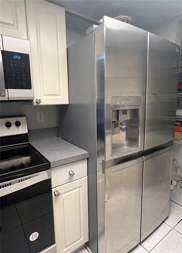 1815 Townhall Ln Unit 1815, Orlando, FL 32807 - kitchen featuring appliances with stainless steel finishes, light tile patterned floors, white cabinets, and light countertops