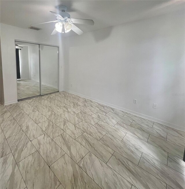 1815 Townhall Ln Unit 1815, Orlando, FL 32807 - unfurnished bedroom with a closet, a ceiling fan, light marble finish flooring, and baseboards