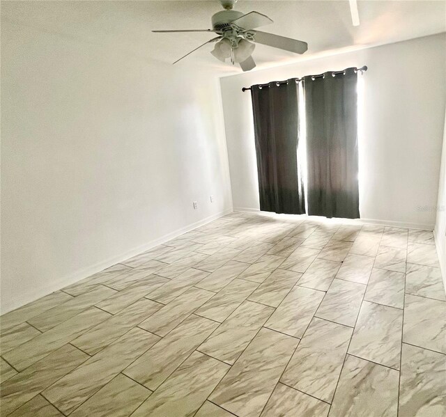 1815 Townhall Ln Unit 1815, Orlando, FL 32807 - unfurnished room featuring a ceiling fan, light marble finish flooring, and baseboards