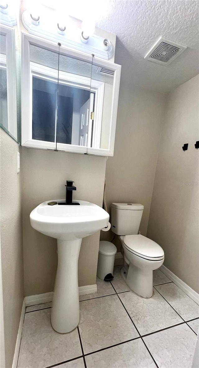 1815 Townhall Ln Unit 1815, Orlando, FL 32807 - bathroom featuring toilet, baseboards, tile patterned flooring, and a textured ceiling