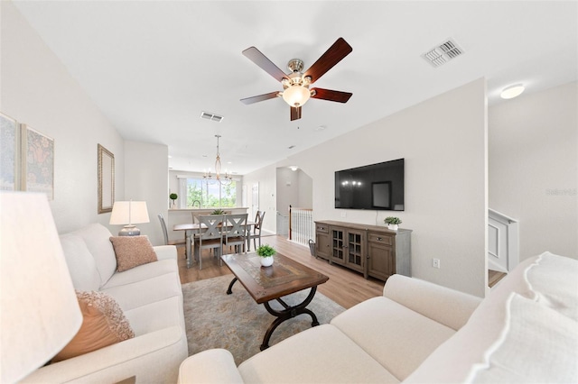 8024 Cool Breeze Dr Unit 132, Orlando, FL 32819 - living room featuring light wood-style flooring, a chandelier, ceiling fan, and baseboards