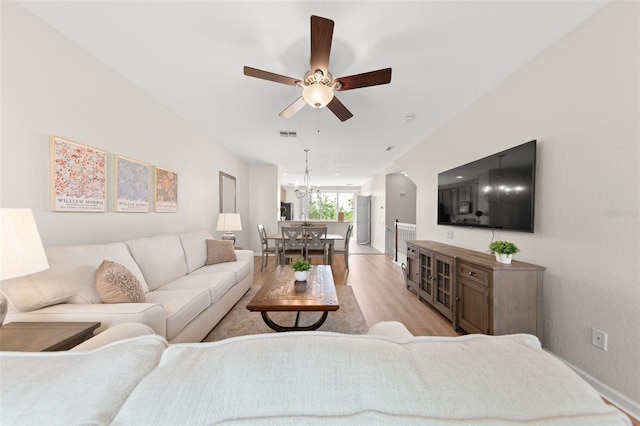 8024 Cool Breeze Dr Unit 132, Orlando, FL 32819 - living room with light wood-style floors, ceiling fan, baseboards, and a chandelier