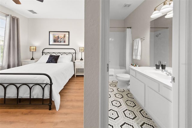 8024 Cool Breeze Dr Unit 132, Orlando, FL 32819 - bedroom featuring light wood-style floors, a sink, and a ceiling fan