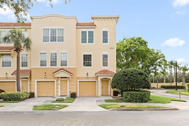8024 Cool Breeze Dr Unit 132, Orlando, FL 32819 - view of front of property featuring a tiled roof, stucco siding, a garage, and driveway