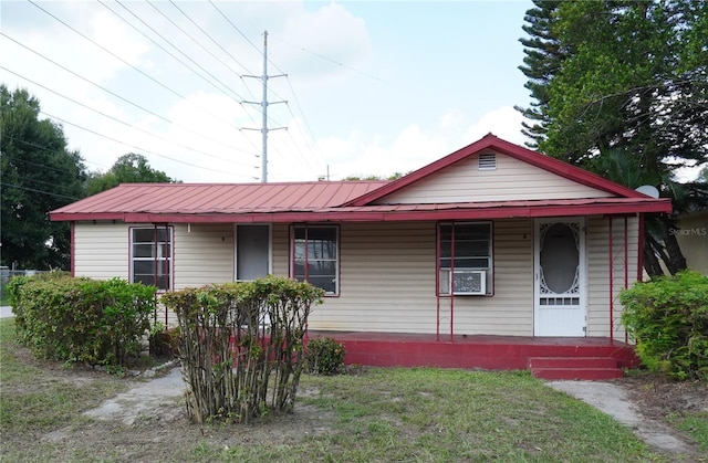 622 Booker, Lake Wales, FL 33853 - view of front of property featuring covered porch, metal roof, and a front lawn