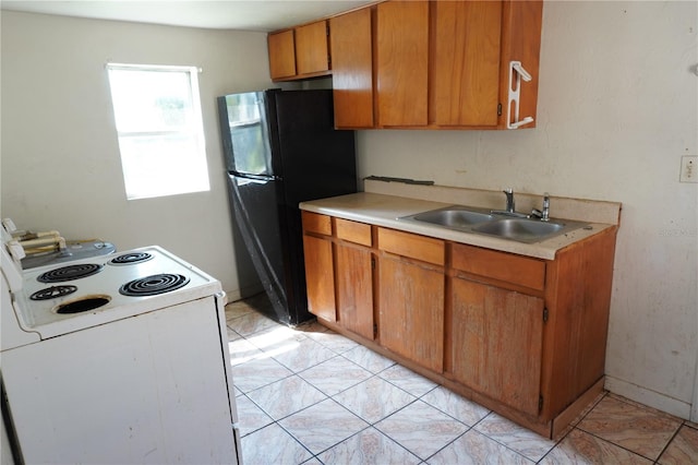 622 Booker, Lake Wales, FL 33853 - kitchen with electric range, a sink, freestanding refrigerator, light countertops, and brown cabinets