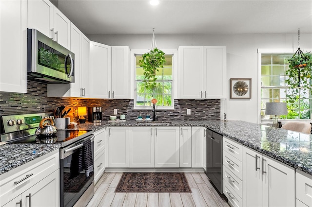 489 Grape Ave, Saint Cloud, FL 34769 - kitchen featuring stainless steel appliances, a sink, white cabinetry, light wood-type flooring, and backsplash