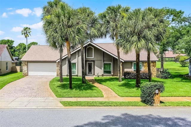 526 Sabal Trail Cir, Longwood, FL 32779 - mid-century inspired home featuring stone siding, driveway, an attached garage, a front lawn, and roof with shingles
