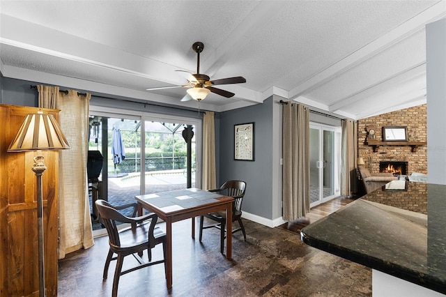 526 Sabal Trail Cir, Longwood, FL 32779 - dining area featuring ceiling fan, a fireplace, a textured ceiling, and dark stone finish floors
