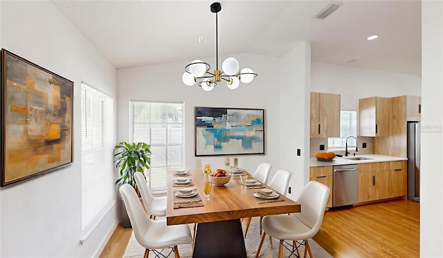 10747 Satinwood Cir, Orlando, FL 32825 - dining area with vaulted ceiling, a chandelier, and light wood-type flooring