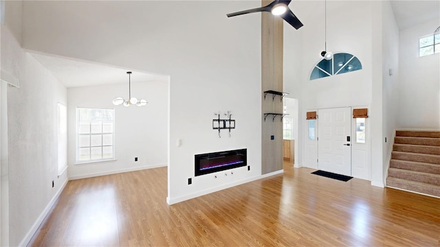 10747 Satinwood Cir, Orlando, FL 32825 - entrance foyer with high vaulted ceiling, a chandelier, light wood-style floors, stairs, and baseboards