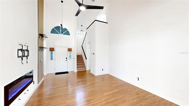 10747 Satinwood Cir, Orlando, FL 32825 - foyer entrance featuring a high ceiling, light wood-style floors, stairway, and baseboards