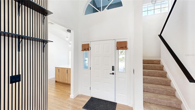 10747 Satinwood Cir, Orlando, FL 32825 - foyer entrance with light wood-type flooring, stairs, a high ceiling, and baseboards