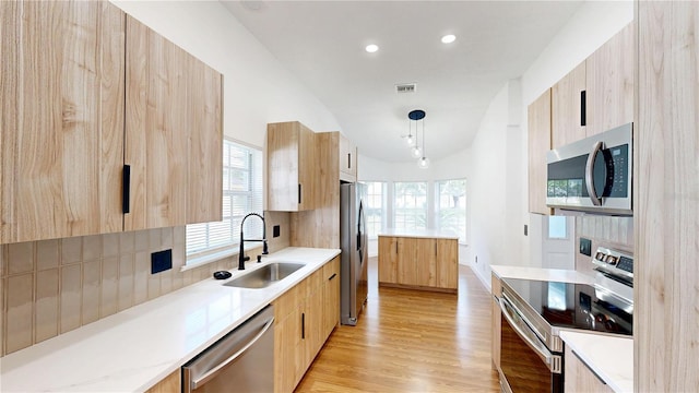 10747 Satinwood Cir, Orlando, FL 32825 - kitchen featuring appliances with stainless steel finishes, a sink, modern cabinets, light brown cabinets, and healthy amount of natural light