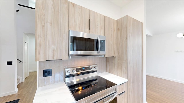10747 Satinwood Cir, Orlando, FL 32825 - kitchen with light brown cabinets, appliances with stainless steel finishes, modern cabinets, and light stone counters