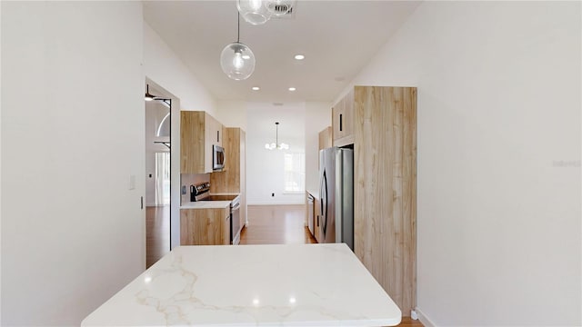 10747 Satinwood Cir, Orlando, FL 32825 - kitchen featuring stainless steel appliances, light brown cabinets, modern cabinets, wood finished floors, and a chandelier