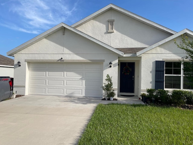 7172 SW 135th Pl, Ocala, FL 34473 - view of front facade featuring stucco siding, an attached garage, and driveway