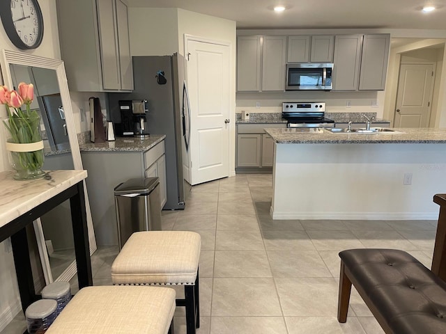 7172 SW 135th Pl, Ocala, FL 34473 - kitchen featuring appliances with stainless steel finishes, gray cabinetry, light stone countertops, recessed lighting, and light tile patterned floors