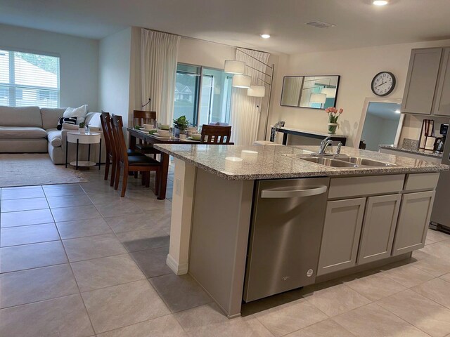 7172 SW 135th Pl, Ocala, FL 34473 - kitchen with stainless steel dishwasher, gray cabinets, an island with sink, light stone countertops, and light tile patterned floors