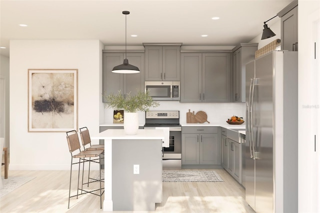 8231 N Wakefield Dr Unit 31, Dunnellon, FL 34434 - kitchen with appliances with stainless steel finishes, gray cabinetry, light wood-type flooring, light countertops, and a breakfast bar