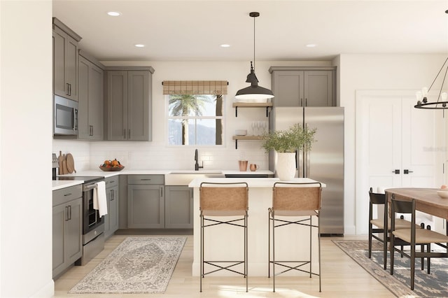 8231 N Wakefield Dr Unit 31, Dunnellon, FL 34434 - kitchen with stainless steel appliances, gray cabinets, a sink, decorative backsplash, and light wood-type flooring