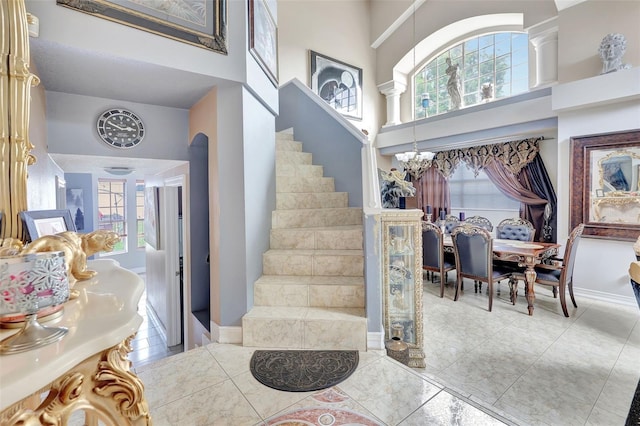 2971 Cayman Way, Orlando, FL 32812 - foyer featuring a high ceiling, stairway, healthy amount of natural light, light tile patterned floors, and baseboards