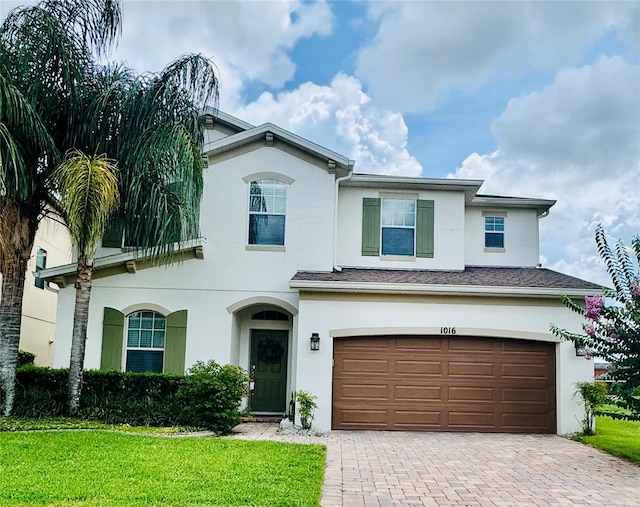 1016 Fountain Coin Loop, Orlando, FL 32828 - view of front of house featuring stucco siding, a garage, decorative driveway, and a front lawn