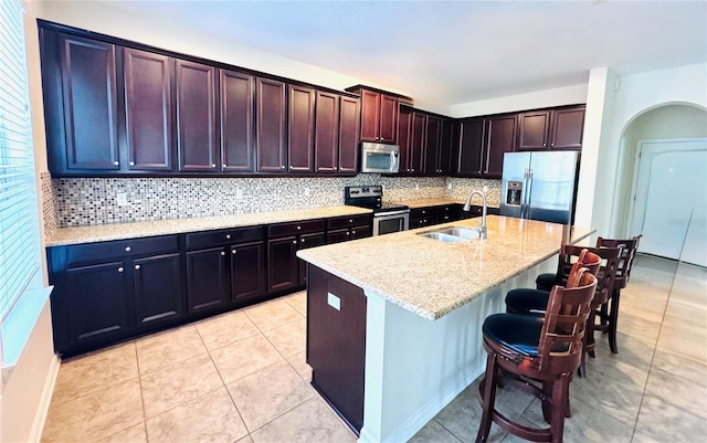 1016 Fountain Coin Loop, Orlando, FL 32828 - kitchen with stainless steel appliances, decorative backsplash, a kitchen bar, and light stone countertops