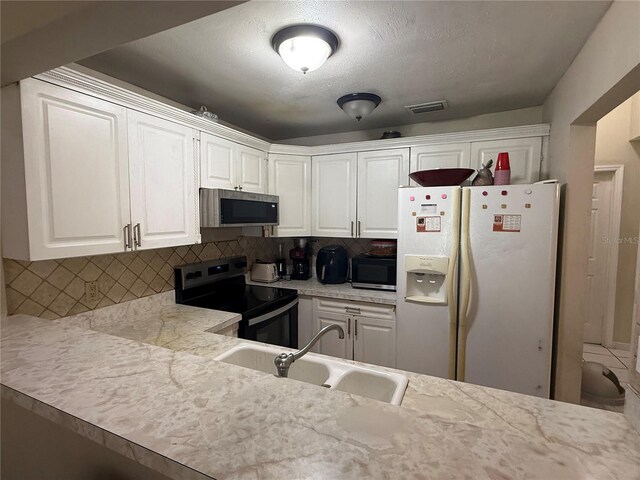 7104 Blue Earth Ct, Orlando, FL 32818 - kitchen with white fridge with ice dispenser, stainless steel microwave, electric stove, and a sink