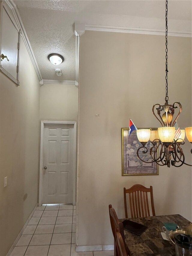 7104 Blue Earth Ct, Orlando, FL 32818 - dining room featuring a textured ceiling, light tile patterned floors, crown molding, baseboards, and a chandelier