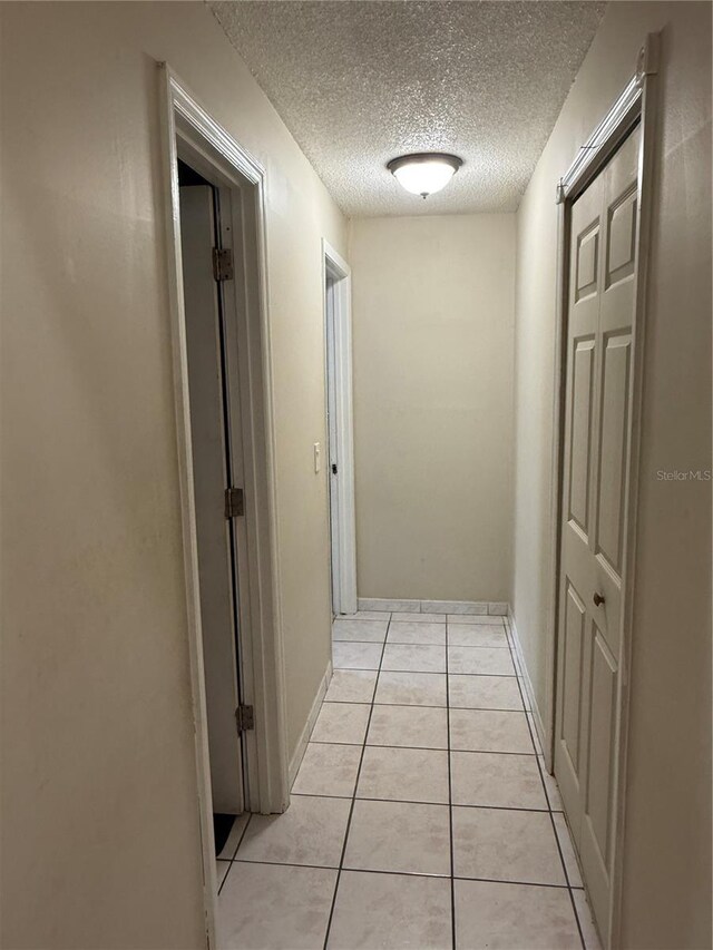 7104 Blue Earth Ct, Orlando, FL 32818 - corridor featuring a textured ceiling and light tile patterned flooring