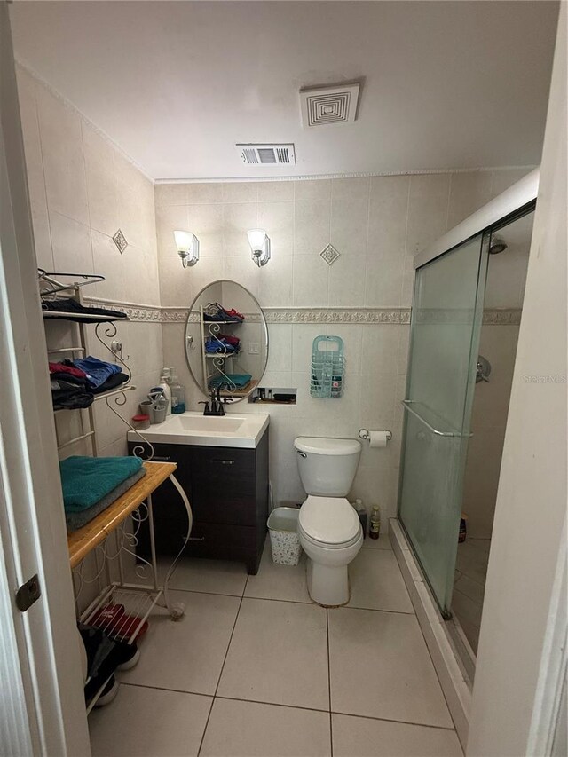 7104 Blue Earth Ct, Orlando, FL 32818 - bathroom featuring tile walls, vanity, tile patterned flooring, toilet, and a shower stall