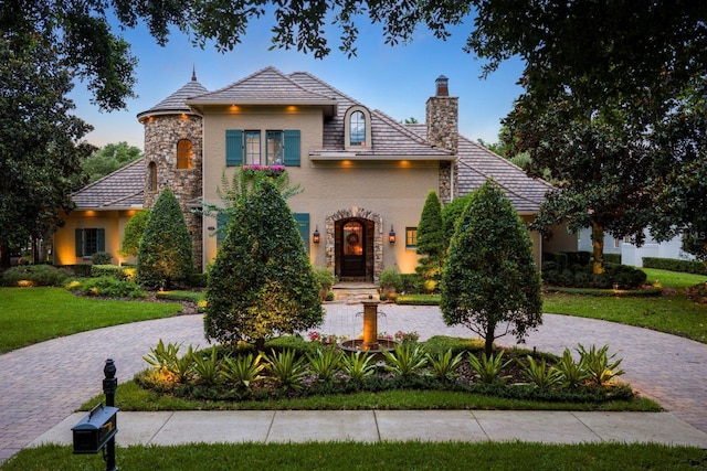 11106 Coniston Way, Windermere, FL 34786 - view of front of house with a chimney, stucco siding, a front lawn, and stone siding