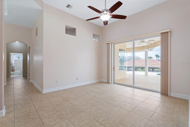 5 Florence Ct, Palm Coast, FL 32137 - empty room featuring ceiling fan, arched walkways, light tile patterned floors, baseboards, and a high ceiling