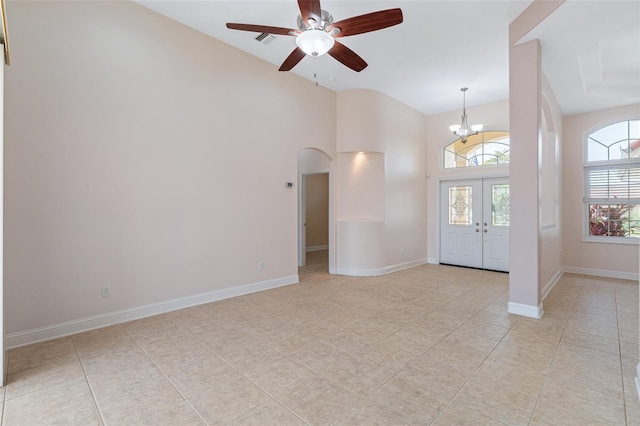 5 Florence Ct, Palm Coast, FL 32137 - empty room featuring arched walkways, a ceiling fan, light tile patterned floors, a chandelier, and high vaulted ceiling