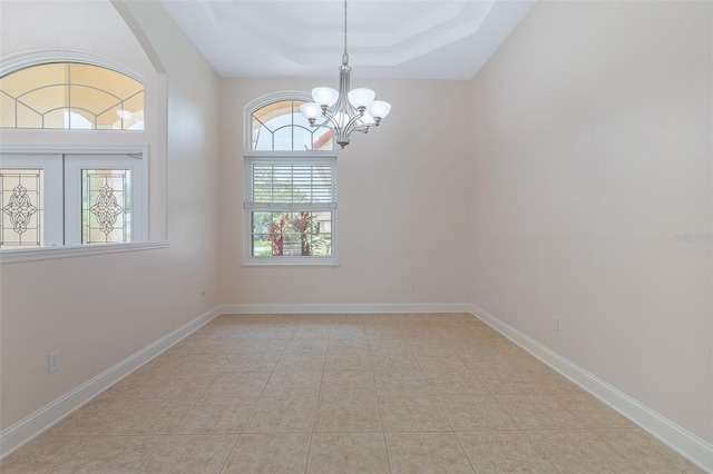 5 Florence Ct, Palm Coast, FL 32137 - spare room with a chandelier, a tray ceiling, arched walkways, tile patterned floors, and baseboards