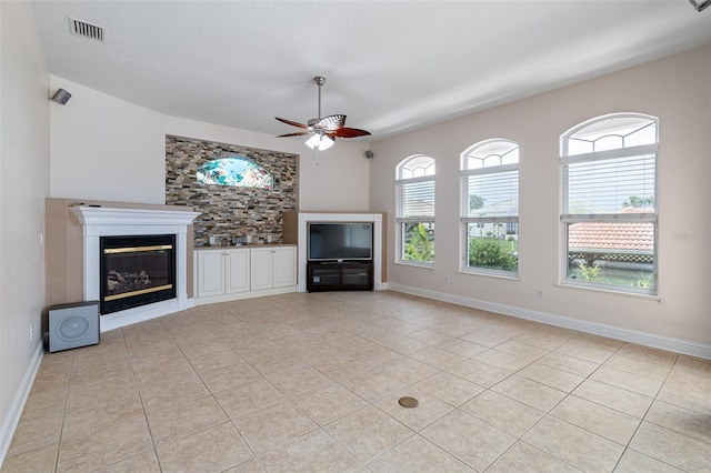 5 Florence Ct, Palm Coast, FL 32137 - unfurnished living room with a ceiling fan, light tile patterned floors, a glass covered fireplace, and baseboards