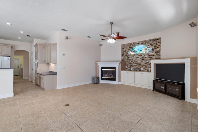 5 Florence Ct, Palm Coast, FL 32137 - unfurnished living room with ceiling fan, light tile patterned floors, a glass covered fireplace, recessed lighting, and arched walkways