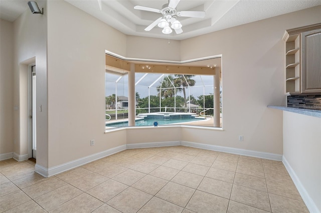 5 Florence Ct, Palm Coast, FL 32137 - unfurnished dining area featuring ceiling fan, light tile patterned floors, a raised ceiling, and baseboards