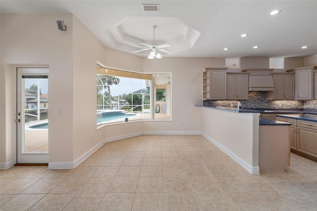 5 Florence Ct, Palm Coast, FL 32137 - kitchen with dark countertops, a ceiling fan, tasteful backsplash, a raised ceiling, and light tile patterned flooring