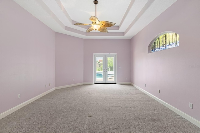 5 Florence Ct, Palm Coast, FL 32137 - empty room featuring a raised ceiling, french doors, ceiling fan, carpet flooring, and baseboards