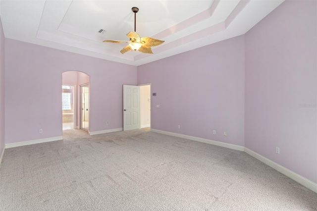 5 Florence Ct, Palm Coast, FL 32137 - unfurnished room featuring a raised ceiling, arched walkways, a ceiling fan, and light colored carpet