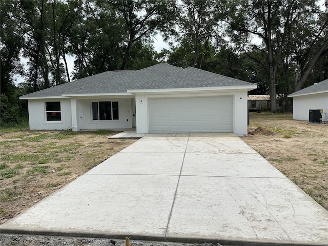 14489 SE 38th Ter, Summerfield, FL 34491 - view of front of property featuring cooling unit, a garage, driveway, and a shingled roof