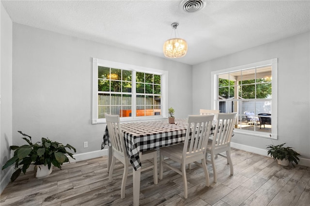 3251 Wickersham Ct, Orlando, FL 32806 - dining room featuring a chandelier, wood finished floors, and a textured ceiling