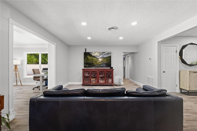 3251 Wickersham Ct, Orlando, FL 32806 - living room with light wood-style flooring, a textured ceiling, and recessed lighting