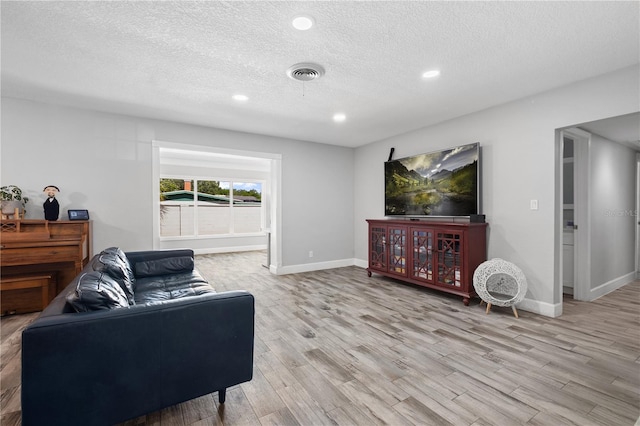 3251 Wickersham Ct, Orlando, FL 32806 - living area featuring light wood-style flooring, a textured ceiling, and recessed lighting