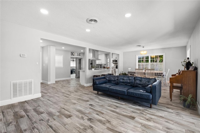 3251 Wickersham Ct, Orlando, FL 32806 - living room with a textured ceiling, light wood-style floors, recessed lighting, and a chandelier