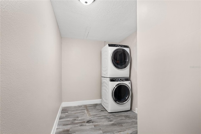 3251 Wickersham Ct, Orlando, FL 32806 - washroom with stacked washing machine and dryer, wood finished floors, and a textured ceiling