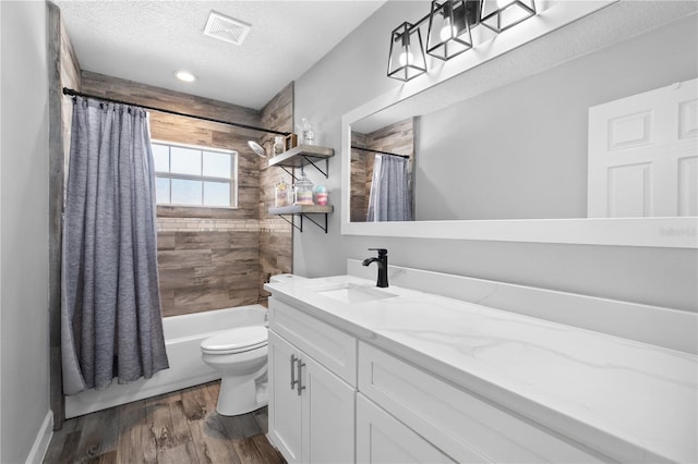 3251 Wickersham Ct, Orlando, FL 32806 - full bathroom featuring wood finished floors, vanity, shower / tub combo, and a textured ceiling