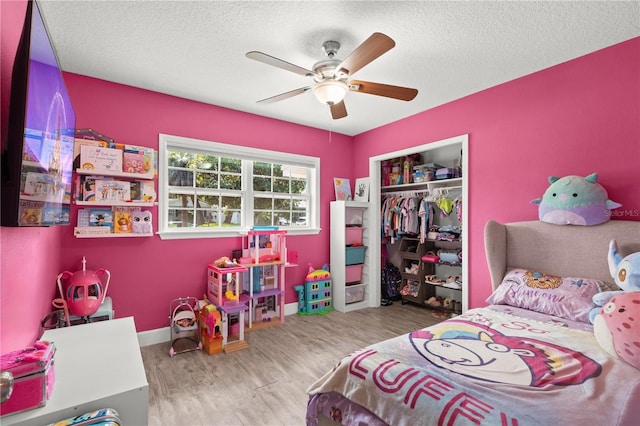 3251 Wickersham Ct, Orlando, FL 32806 - bedroom with wood finished floors, a textured ceiling, a closet, and a ceiling fan